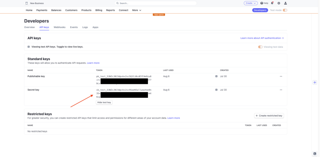 The Stripe dashboard with an arrow showing where to look for API keys. The keys are blackend out to hide sensitive information.